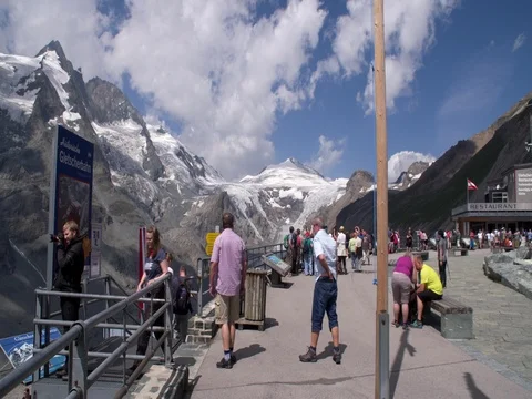 People admiring the view at mountain top with a glacier in Austria Stock Footage 79899313