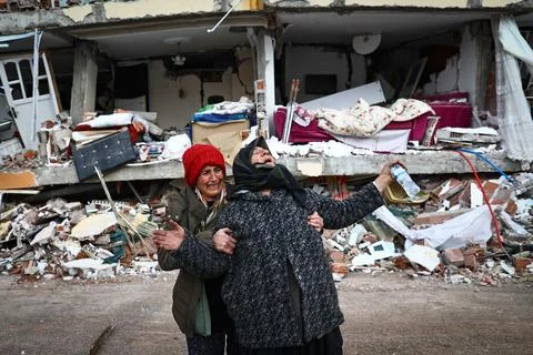 People affected by a major earthquake react at the site of collapsed buildings i Stock Photos