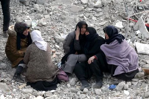 People affected by a powerful earthquake react at the site of collapsed building Stockfoto's