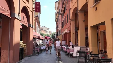 People and bikes pass along a street with restaurants, Bologna, Italy. Stock Footage 339062907