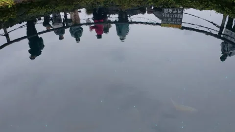 People and cloudy sky reflecting on a Japanese pond Stock Footage 331313253