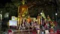 People and Golden Buddha statue inside temple in the cave, Thailand HD Footage
