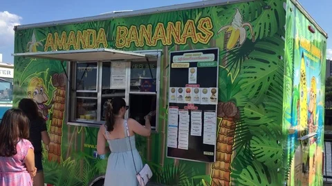 People and millenials wait in line to order meals from a popular food truck on a Stock Footage 70175227