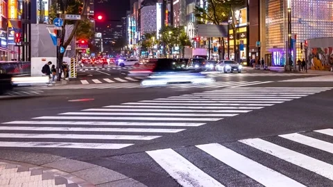 People and traffic cross an intersection in Ginza retail district in Tokyo Vidéo 225295018