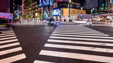 People and traffic cross an intersection in Ginza retail district in Tokyo Vidéo 225296365