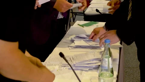 People are counting votes at a large table. Stacks of papers for different Stock Footage 199271143
