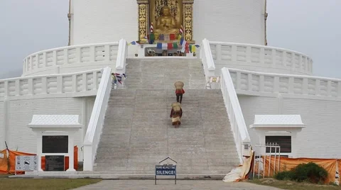 People are dragging baskets of sand up to the Stupa Video stock 57859968