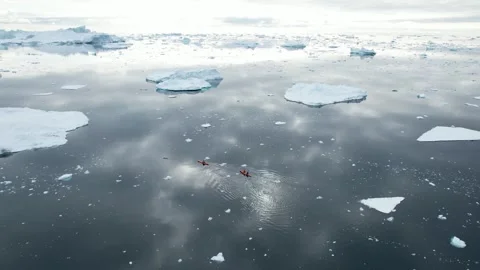 People are exploring cold waters of Greenland in kayaks. Polar landscape Stock Footage 252107121