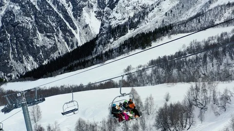 People are going up the ski elevator in the mountains, gorgeous background, 4k Stock Footage 105777142