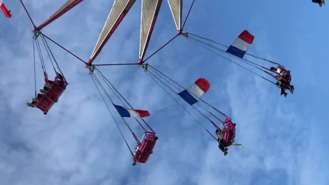 People are having fun on a flying chairs at amusement park in Paris city Stock Footage 131179090