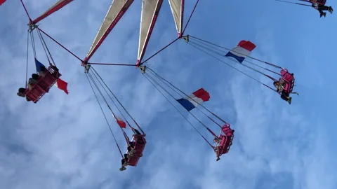 People are having fun on a flying chairs at amusement park in Paris city Stock Footage 131249124