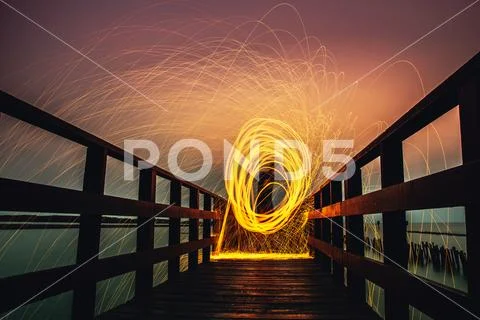 People are holding fireworks and spin on long bridge view at sea landscapes Stock Photos