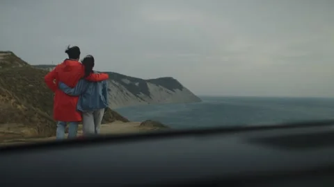 People are hugging out at the ocean as they stand on edge of hill Video stock 342413093