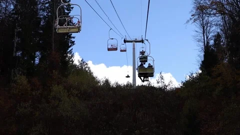 People are lifting up on a elevator in autumntime outdoors. Blue sky Stock Footage 206963483