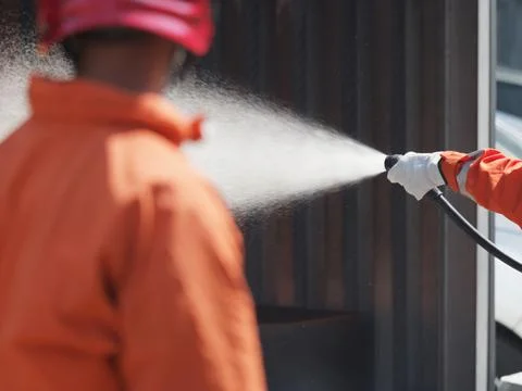 People are practicing fire extinguishers with water. Stock Photos