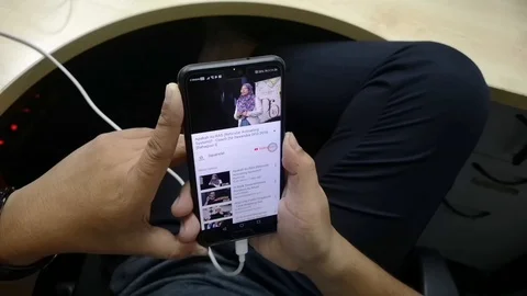 People are relaxing while browsing Youtube app on their mobile phone. Stock Footage 95876731