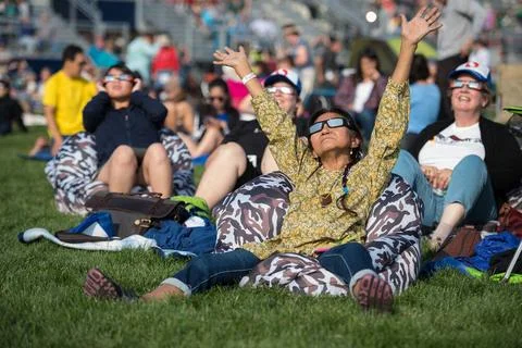 People are seen as they watch a total solar eclipse through protective gla... Stock Photos