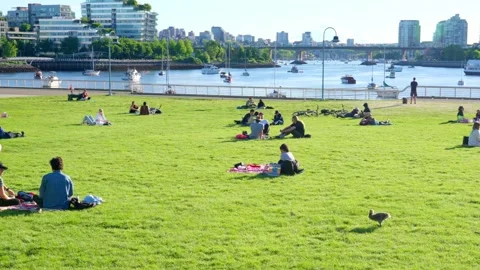People are sitting in groups by the Science World, Vancouver, Canada, May 2021 Stock Footage 155082939