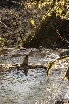 People are sitting on rocks in the river Stock Photos