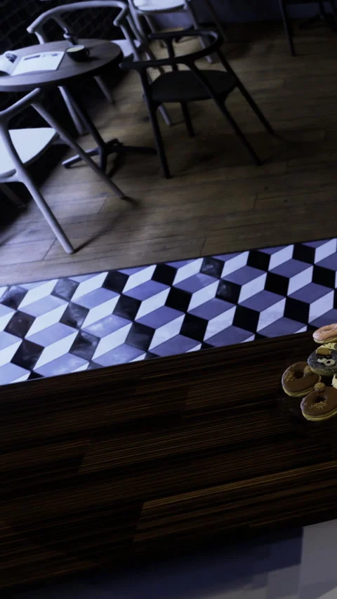 People are sitting at tables with a patterned floor in a cafe setting Stock Footage 335450666