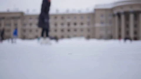 People are skating on the open skating ring on a cloudy day in winter in Vidéo 70064673