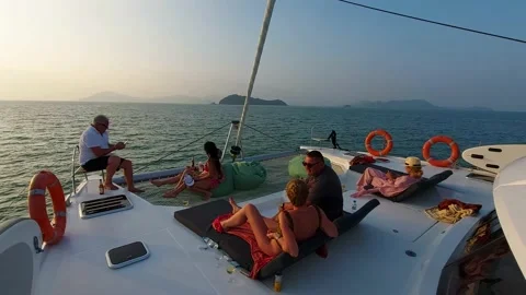 People are talking and drinking on the bow of the boat Stock Footage 186930393