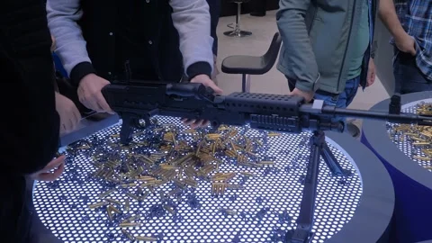 People are testing a new model of a machine gun at the military trade show Stock Footage 329945150