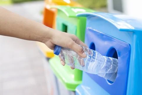 People are throwing empty plastic bottles into recycling bins. Stock Photos