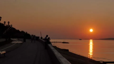 People are walking on the beach during a beautiful sunset. Silhouettes of men Stock Footage 88094548