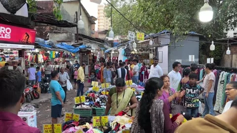 People are walking, browsing, and buying various goods from local vendors Vídeo Stock 336942717
