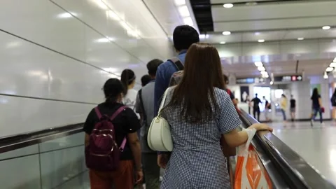People are walking (or using moving walkway) in the MTR subway tunn Stock Footage 153085447