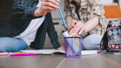 People are working together on a project while sitting on the floor in a cozy Stock Footage 346185935
