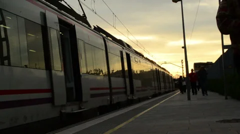 People arriving on train during sunset Stock Footage 33548077