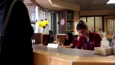 People asking direction at guest services counter inside Eagle Ridge hospital Stock Footage 71700288