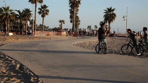 People on an asphalt "boardwalk" on Venice Beach, California Stock Footage 59335540
