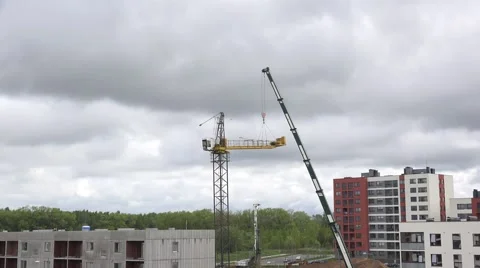 People assemble crane on cloudy sky background. 4K Stock Footage 56634420