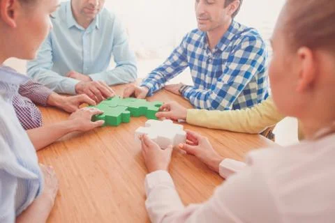 People assembling jigsaw puzzle Stock Photos