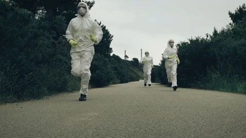 People with bacteriological protection suits running Stock Footage 119814580