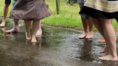 People barefoot jumping in a puddle in the rain Stock Footage 306153511