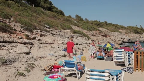 People bathe and rest on the beach. Spanish beaches in Cala Mendia. Mallorca Stock Footage 75547637
