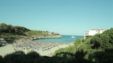 People bathe and rest on the beach. Spanish beaches in Cala Mendia. Mallorca Stock Footage 75556911