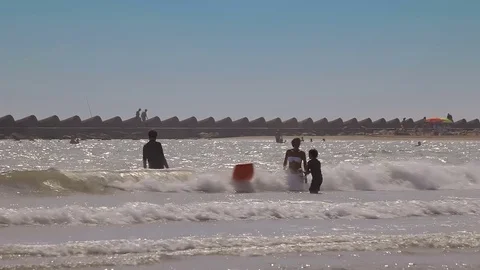 People bathe and rest on the beach. Spanish beaches in Catalonia. Stock Footage 75564606