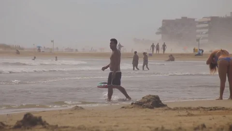 People bathe and rest on the beach. Spanish beaches in Catalonia. Stock Footage 75564948