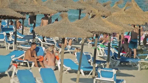 People bathe and rest on the beach. Spanish beaches in Cala Mendia. Mallorca Stock Footage 75590226