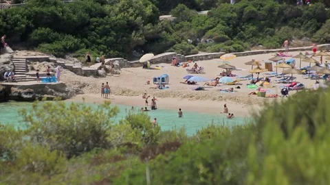 People bathe and rest on the beach. Spanish beaches in Cala Mendia. Mallorca Stock Footage 75609490