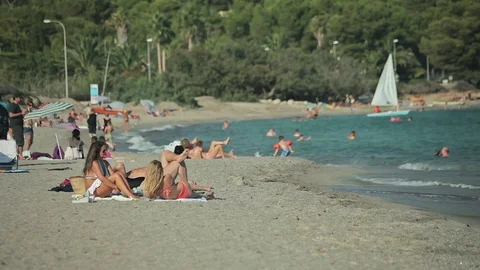 People bathe and rest on the beach. Spanish beaches in Mallorca Young girls in Stock Footage 75619230