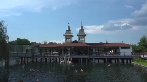 People bathing outdoor in spa complex on thermal Heviz lake, Hungary - 4K Stock Footage 195336662