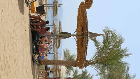 People at the beach lying under the beach umbrella Video stock 91161109