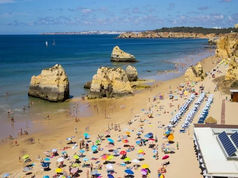 People on beach with Rocks an clouds. Timelaps 스톡 동영상 77343207