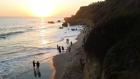 People on the beach at sunset Stockbeeldmateriaal 81096763